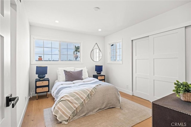 bedroom featuring recessed lighting, multiple windows, and light wood finished floors