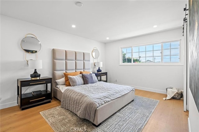 bedroom with light wood finished floors, baseboards, and recessed lighting