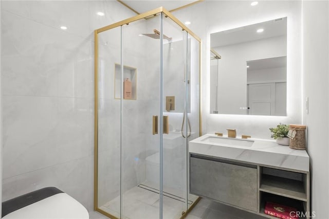 bathroom with toilet, a stall shower, and vanity