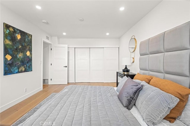 bedroom with baseboards, visible vents, recessed lighting, and light wood-type flooring