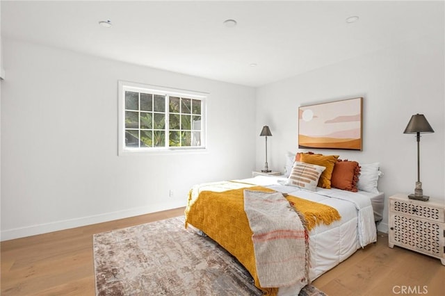 bedroom featuring baseboards and wood finished floors
