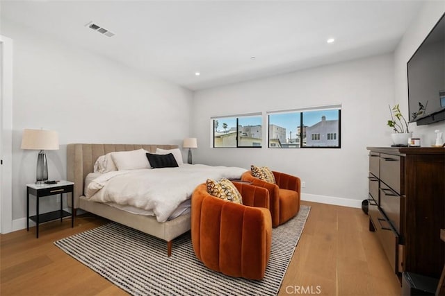 bedroom featuring light wood-type flooring, recessed lighting, baseboards, and visible vents