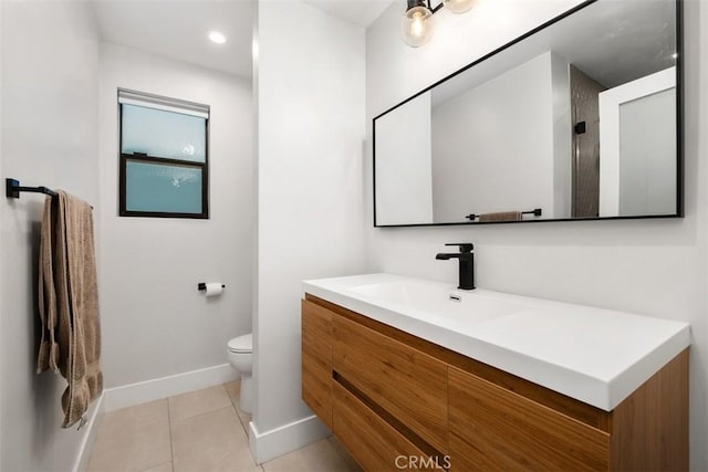 bathroom with tile patterned floors, toilet, vanity, and baseboards