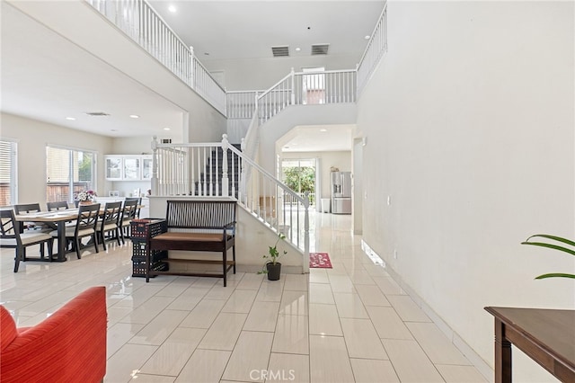 25445 Clovelly Ct, Moreno Valley, CA 92553 - entrance foyer with stairs, visible vents, a high ceiling, and a wealth of natural light