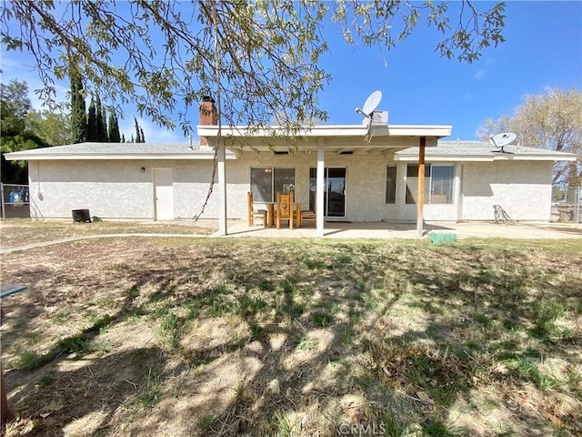 11031 Victor Ave, Hesperia, CA 92345 - back of house with a chimney, stucco siding, a patio, and ceiling fan