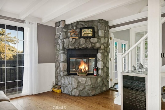 475 Woodsey Rd, Crestline, CA 92325 - living area with hardwood / wood-style floors, a wainscoted wall, a stone fireplace, and beamed ceiling