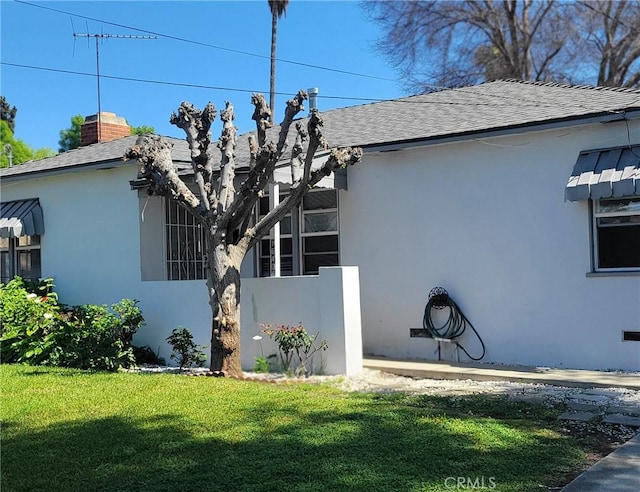 1640 Alameda St, Pomona, CA 91768 - view of home's exterior with a yard, a chimney, roof with shingles, and stucco siding