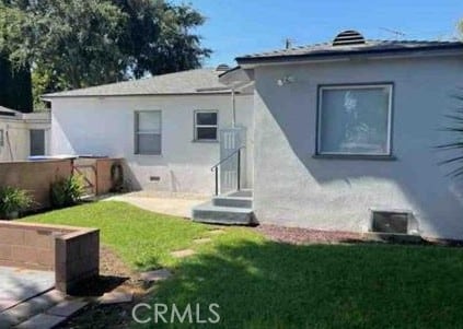 1640 Alameda St, Pomona, CA 91768 - back of house with stucco siding and a lawn