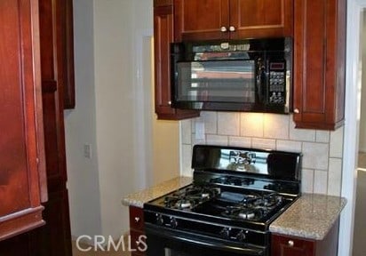 1640 Alameda St, Pomona, CA 91768 - kitchen with decorative backsplash, black appliances, and light stone counters