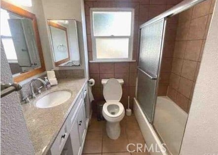 1640 Alameda St, Pomona, CA 91768 - full bathroom featuring combined bath / shower with glass door, tile patterned flooring, vanity, and toilet