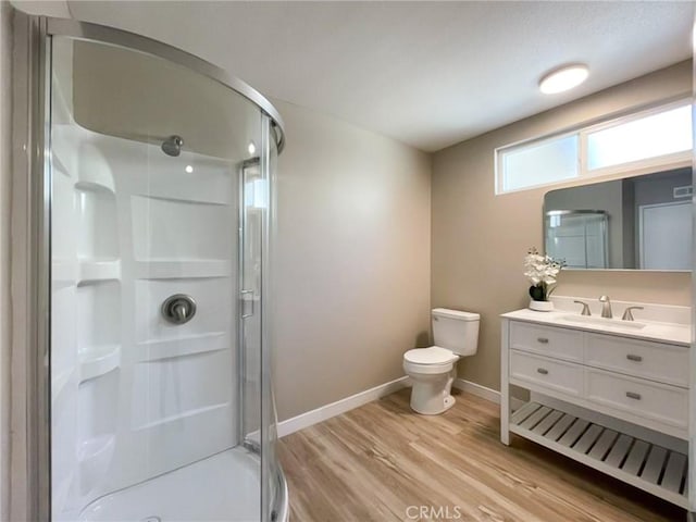 full bath featuring toilet, a stall shower, wood finished floors, and baseboards