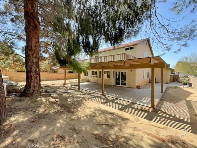 back of house with stucco siding, fence, and a patio area