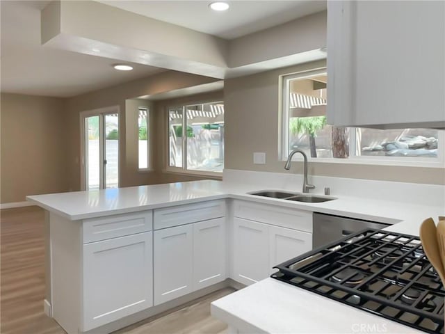 43856 Windsor Pl, Lancaster, CA 93536 - kitchen featuring a peninsula, light countertops, white cabinets, recessed lighting, and light wood-style floors
