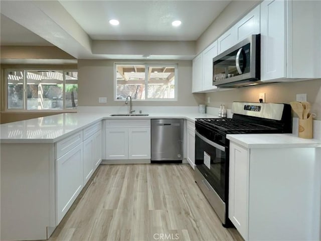 43856 Windsor Pl, Lancaster, CA 93536 - kitchen featuring stainless steel appliances, light wood-style floors, white cabinetry, a peninsula, and recessed lighting