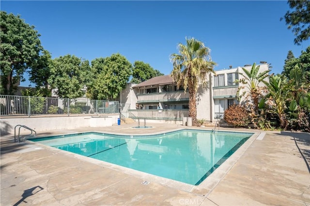pool featuring fence and a patio