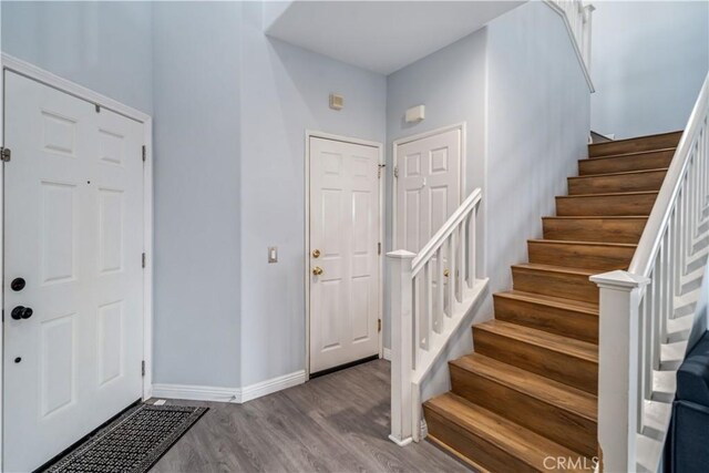 entrance foyer featuring baseboards, stairway, and wood finished floors