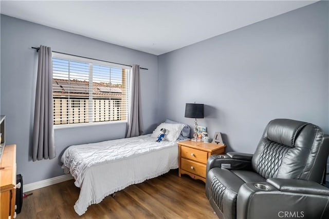 bedroom with baseboards and wood finished floors