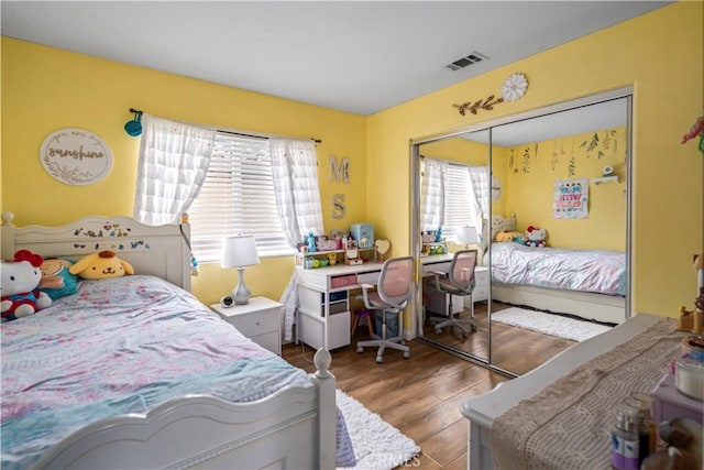 bedroom featuring a closet, visible vents, and wood finished floors