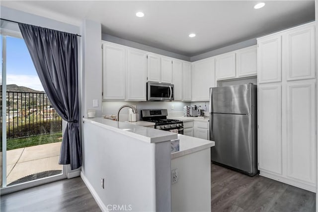 kitchen with dark wood-style floors, white cabinets, and stainless steel appliances