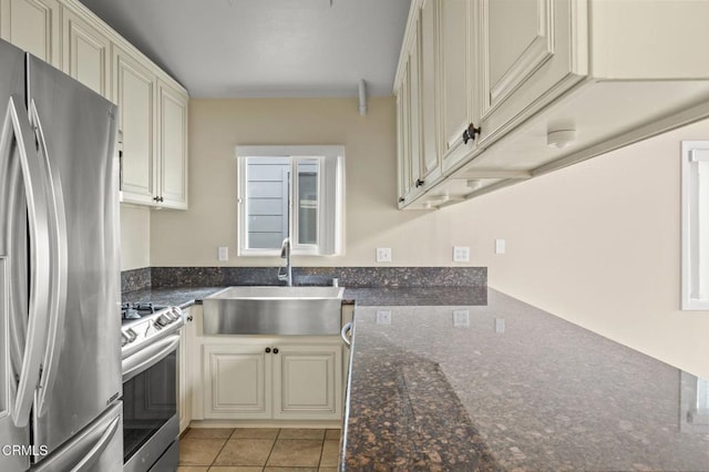 276 Highland Dr, Oxnard, CA 93035 - kitchen featuring stainless steel appliances, a sink, cream cabinets, dark stone countertops, and light tile patterned flooring
