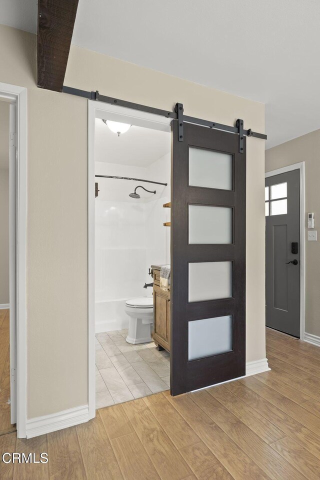 276 Highland Dr, Oxnard, CA 93035 - entryway featuring a barn door, light wood-type flooring, and baseboards