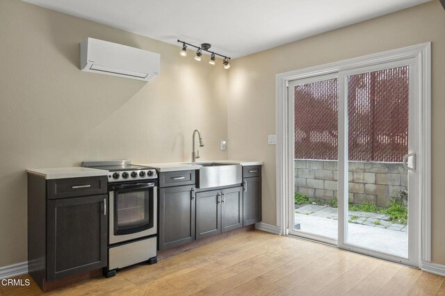 276 Highland Dr, Oxnard, CA 93035 - kitchen featuring stainless steel range with electric cooktop, a wall mounted air conditioner, light wood finished floors, light countertops, and baseboards