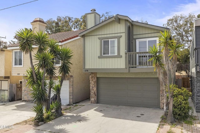 276 Highland Dr, Oxnard, CA 93035 - view of front of house featuring a chimney, stone siding, concrete driveway, a tile roof, and an attached garage