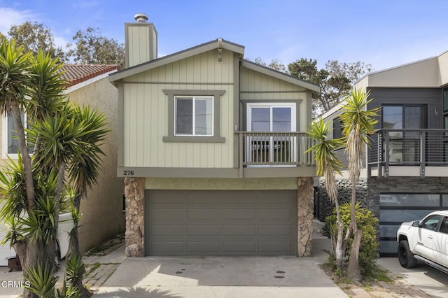 276 Highland Dr, Oxnard, CA 93035 - view of front of property with stone siding, concrete driveway, a garage, a chimney, and a balcony