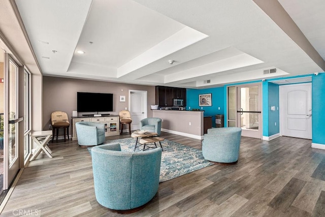 1021 Costa Pacifica Way Unit 2105, Oceanside, CA 92054 - living room featuring a tray ceiling, wood finished floors, and healthy amount of natural light
