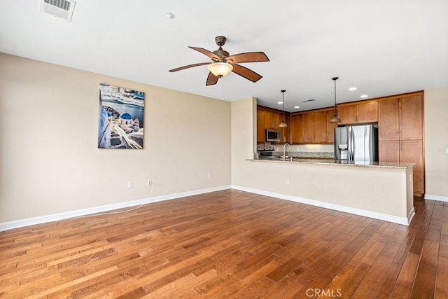1021 Costa Pacifica Way Unit 2105, Oceanside, CA 92054 - kitchen with appliances with stainless steel finishes, brown cabinets, wood-type flooring, ceiling fan, and recessed lighting