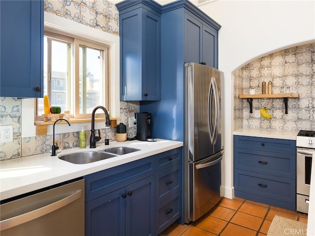 535 E Walnut Ave Unit A, El Segundo, CA 90245 - kitchen with appliances with stainless steel finishes, blue cabinets, light countertops, light tile patterned flooring, and decorative backsplash