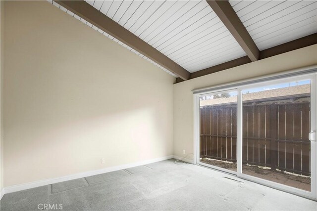 carpeted empty room with lofted ceiling with beams and baseboards