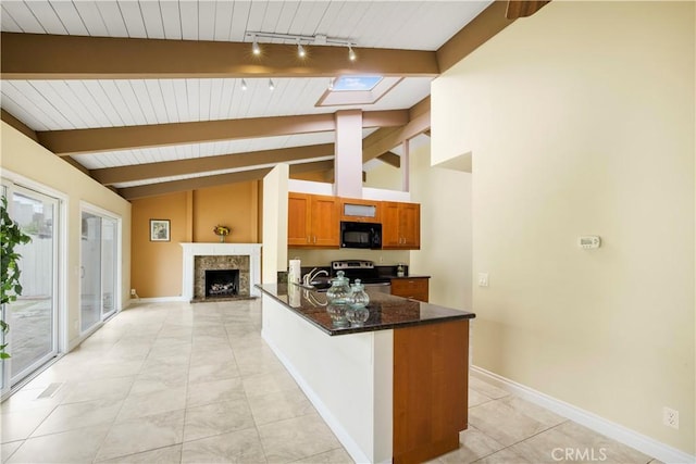 kitchen featuring lofted ceiling with skylight, baseboards, electric stove, black microwave, and brown cabinetry