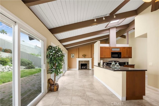 kitchen with black microwave, dark countertops, vaulted ceiling with skylight, and stainless steel electric range