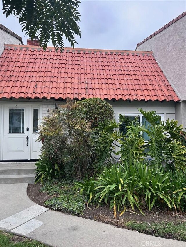 view of front of home with stucco siding and a tile roof