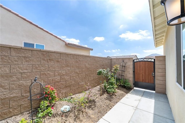 exterior space featuring a fenced backyard and a gate