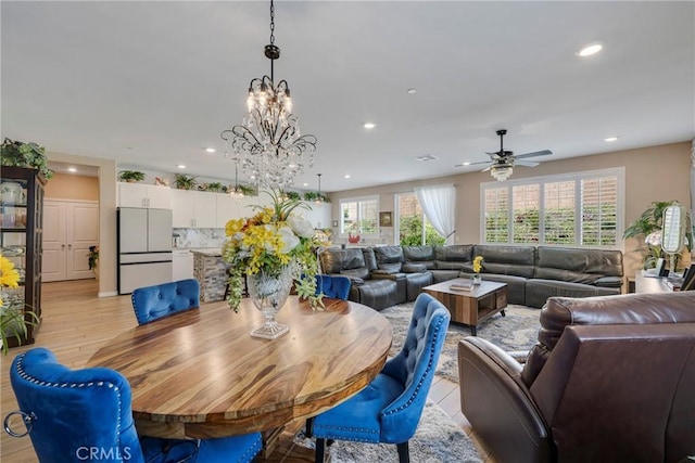 dining room featuring light wood-type flooring, recessed lighting, and ceiling fan with notable chandelier