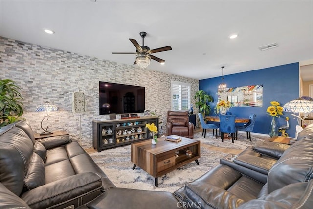 living room with ceiling fan with notable chandelier, visible vents, wood finished floors, and recessed lighting