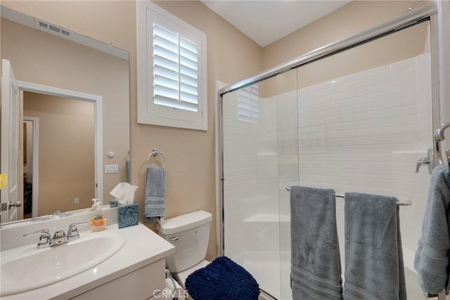 bathroom with vanity, visible vents, toilet, and a shower stall
