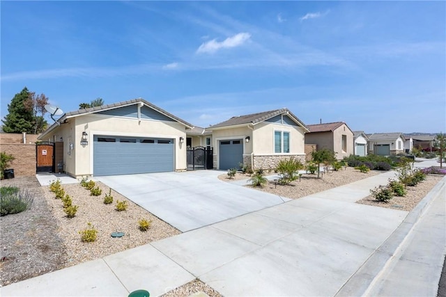 single story home with stone siding, a gate, a garage, stucco siding, and driveway