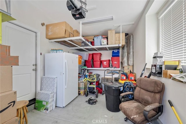 garage with a garage door opener and freestanding refrigerator