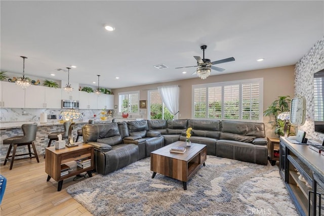 living room with visible vents, recessed lighting, light wood-type flooring, and a ceiling fan