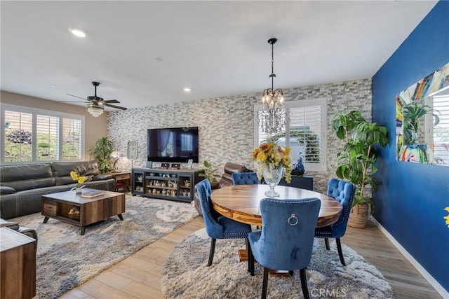dining space with light wood-style flooring, baseboards, recessed lighting, a ceiling fan, and an accent wall