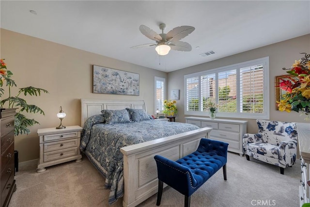 bedroom featuring ceiling fan, visible vents, and light carpet