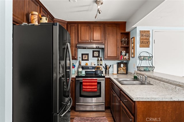 kitchen with a sink, stainless steel appliances, light countertops, under cabinet range hood, and dark wood-type flooring