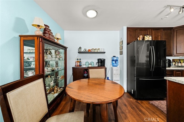 kitchen with dark wood-style flooring, dark brown cabinets, freestanding refrigerator, and light countertops