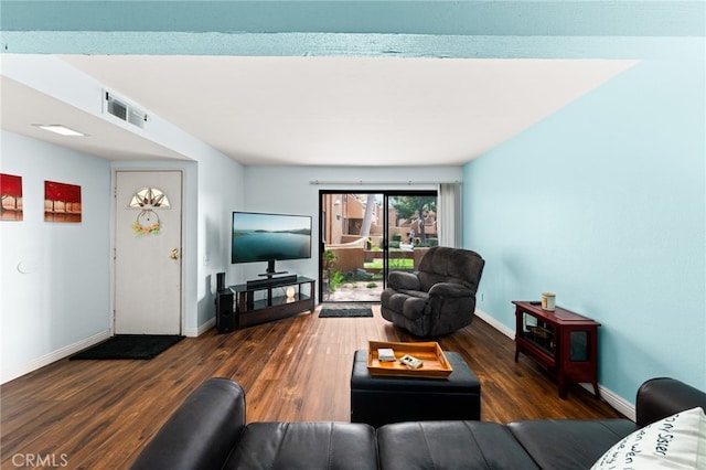 living room with baseboards, visible vents, and wood finished floors