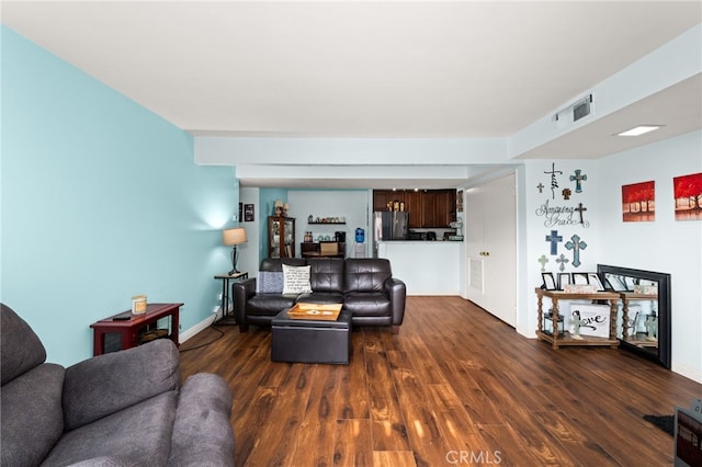 living area with baseboards and wood finished floors