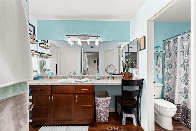 full bathroom featuring toilet, vanity, a shower with curtain, and wood finished floors