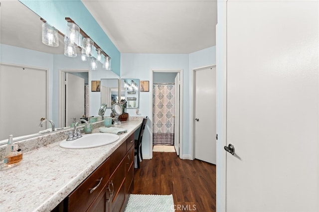 bathroom with vanity, wood finished floors, and baseboards
